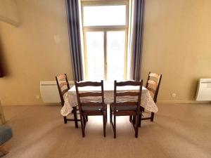 a dining room table with four chairs and a window at Le Repère de Rumaucourt in Rumaucourt