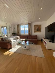 a living room with a couch and a table at Mon Bijou Chalet au Lac Alpin in Thun