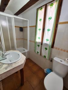 a bathroom with a sink and a toilet and a window at Hotel Rural Papasol in Atapuerca