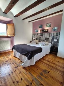 a bedroom with a large bed in a room with wooden floors at Hotel Rural Papasol in Atapuerca