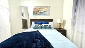 a bedroom with a large bed with blue pillows at Coral Cove Oasis in Discovery Bay +30 photos