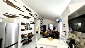 a kitchen and a living room with a refrigerator at Coral Cove Oasis in Discovery Bay