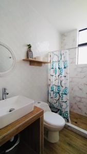 a bathroom with a toilet and a sink and a shower curtain at Casa Miami in Miami