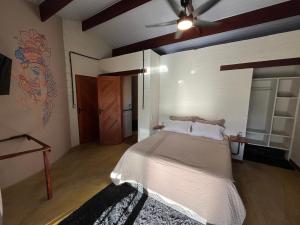 a bedroom with a bed and a ceiling fan at Chalé Mon Amour com sua piscina privativa in São Miguel do Gostoso