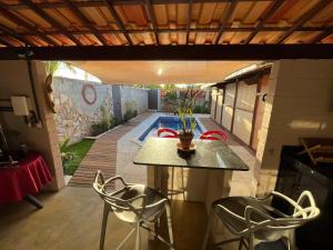 a patio with a table and chairs and a pool at Chalé Mon Amour com sua piscina privativa in São Miguel do Gostoso