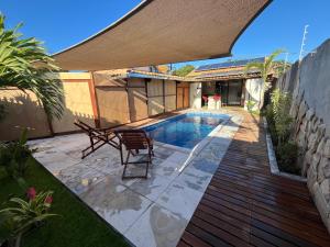 a backyard with a swimming pool and a wooden deck at Chalé Mon Amour com sua piscina privativa in São Miguel do Gostoso +15 photos