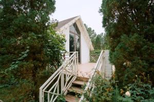 a small white house with a staircase leading to it at Veco Pine in Thạch Cầu
