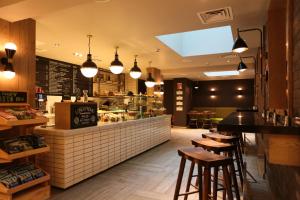 a fast food restaurant with a counter with stools at hub London - Spitalfields in London