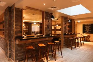 a bar in a restaurant with wooden stools at hub London - Spitalfields in London