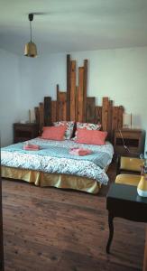 a bedroom with a large bed with a wooden headboard at Le Jardingue - Chambres d'Hôtes in Saint-Moreil