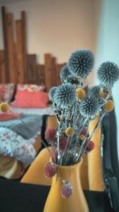 a yellow vase with flowers in it on a table at Le Jardingue - Chambres d'Hôtes in Saint-Moreil