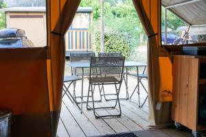a patio with chairs and a table and a table and chairs at Camping Les Aubazines in Bort-les-Orgues