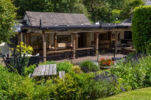 a house with a bench in a garden at Bickley Mill Inn in Newton Abbot