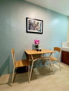 a dining room table and chairs with a vase of flowers on it at Residencia de rubie 2 in Dahikan