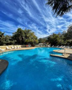 a large swimming pool with chairs and a blue sky at El Copihue Olmué in Olmué
