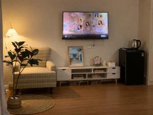 a living room with a television on the wall at Homemie in Binh Hai +9 photos
