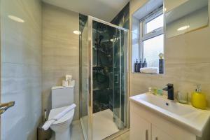 a bathroom with a shower and a toilet and a sink at Contractor Base 4BR Fast WiFi Parking High Wycombe in Buckinghamshire +40 photos