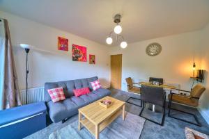 a living room with a blue couch and a table at Contractor Base 4BR Fast WiFi Parking High Wycombe in Buckinghamshire