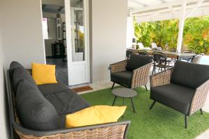 a living room with a couch and chairs and a table at Villa Diams Diamond in Le Diamant