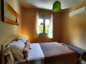 a bedroom with a bed and a window at Villa Eytychia in Kefallonia