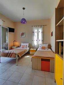 a bedroom with two beds and a window at Villa Eytychia in Kefallonia