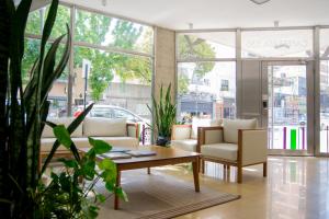 a living room with a table and chairs and windows at Torre Potosi Departamentos in Rosario