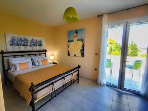a bedroom with a large bed and a balcony at Villa Eytychia in Kefallonia