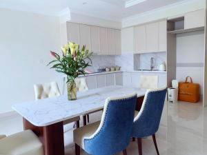 a kitchen with a table with a vase of flowers on it at Homemie in Binh Hai