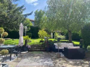 a backyard with a patio furniture and an umbrella at Le vieux colombier in Le Monastier sur Gazeille