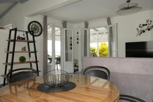 a dining room with a table and chairs and a clock at Villa Diams Diamond in Le Diamant