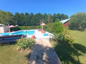 a swimming pool in a yard with a garden at Mi CASA in Sierra de los Padres