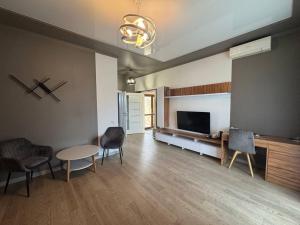 a living room with a tv and a table and chairs at Копа Баварія - Львів Готель in Pasiky-Zubryts'ki