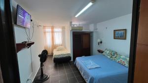 a small room with a bed and a tv at Arauca -Centro in Arauca