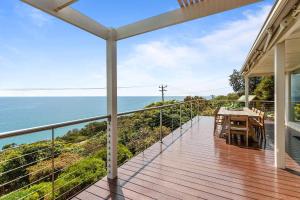 a balcony with a table and a view of the ocean at Clifftop Coastal Sanctuary Panoramic Views in Mount Martha