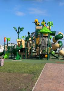 a playground with a bunch of slides in a park at Seaside Caravan in a Leisure Park with WiFi & Parking - 3 bedrooms in Meliden