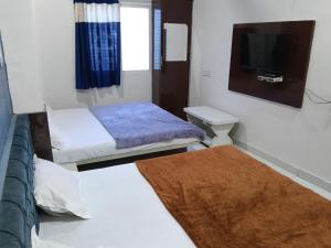 a small room with two beds and a tv at Hotel Sadashiv in Godarpura