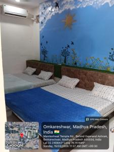 two beds in a room with a blue wall at Hotel Sadashiv in Godarpura