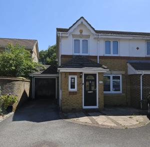 a brick house with a gate and a driveway at Luxury Heathrow Modern House with Parking & Fast WiFi in Northolt