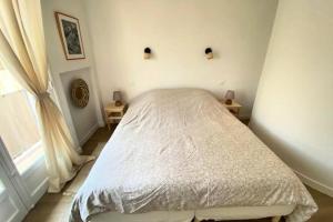 a bedroom with a bed in a room with a window at Spacious house with balcony in Sainte-Maxime