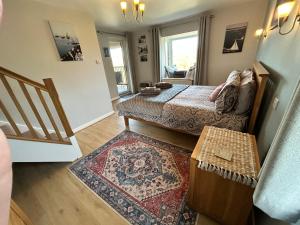 a living room with a bed and a rug at Looe, Cornwall, couples, families, quiet location, views, reliable Wi-Fi, 3 bed LANGUNNETT COTTAGE in Looe