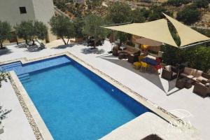 an overhead view of a swimming pool with chairs and tables at ANDA villa&Farm in Amman