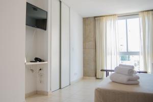 a room with a bed with a television and a window at Torre Potosi Departamentos in Rosario