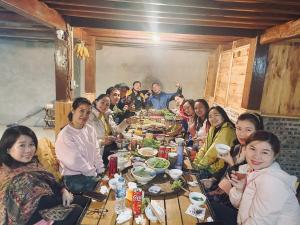 a group of people sitting around a table eating at Sơn Tra Our House in Bản Bé