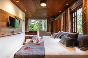 a bedroom with a large bed with red flowers on it at Recanto de Moriá in Penedo