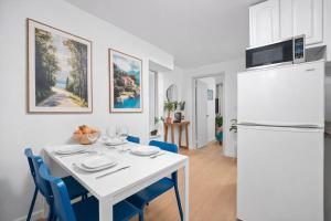 a kitchen and dining room with a white table and a refrigerator at Cozy 4BD Unit in Lower Manhattan in New York