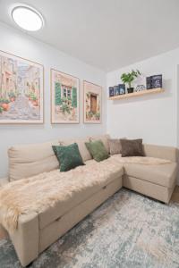 a couch in a living room with paintings on the wall at Cozy 4BD Unit in Lower Manhattan in New York
