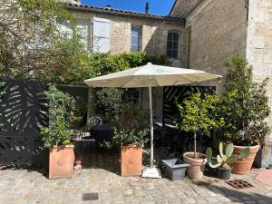 an umbrella in front of a house with potted plants at L Atelier in Angoulême