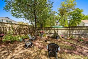 a yard with chairs and a fence with a tree at Whispering Marsh Hideaway - Peaceful House in Myrtle Beach