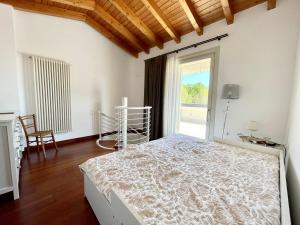 a bedroom with a bed and a large window at Villa Gardoncino in Manerba del Garda