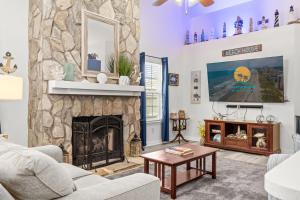 a living room with a stone fireplace at Whispering Marsh Hideaway - Peaceful House in Myrtle Beach